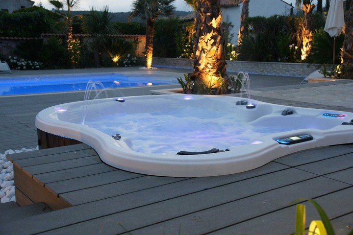 Amore Bay hot tub at dusk in a spacious backyard.